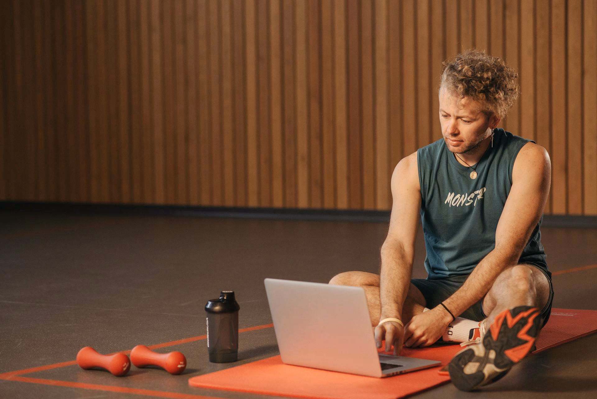 Person sitzt mit Laptop auf dem Boden