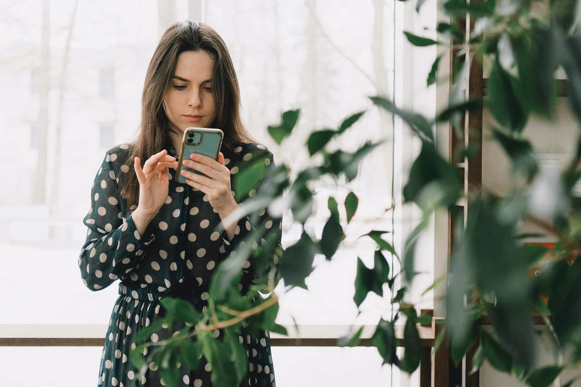 women in green shirt sing mobile phone